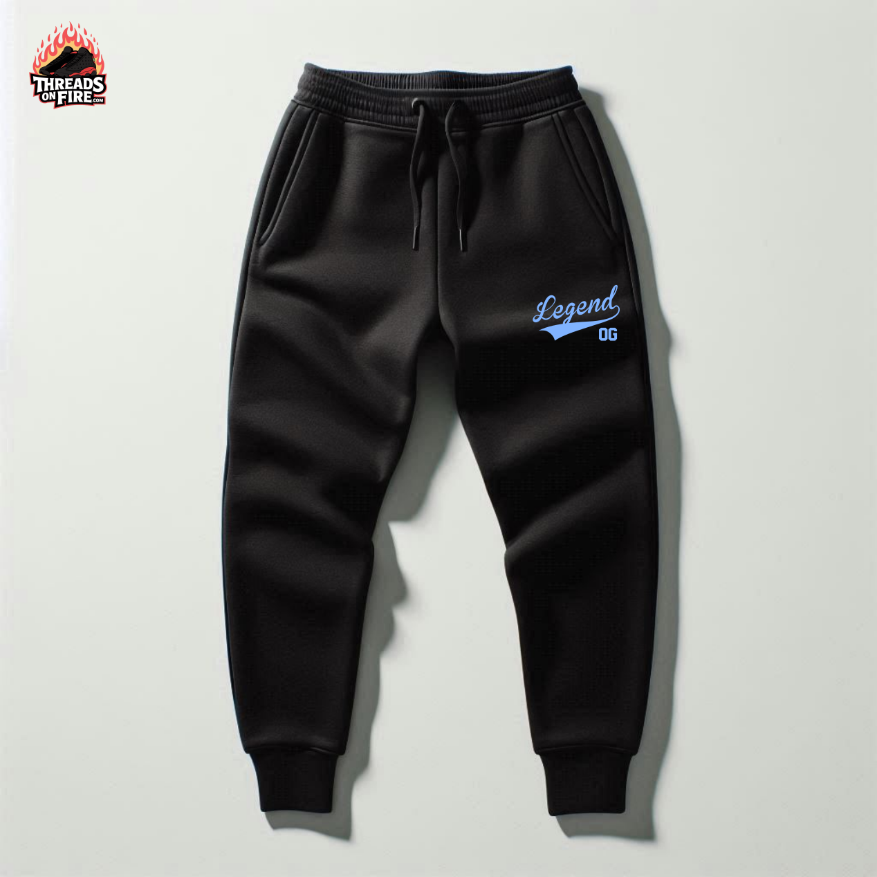 Black sweatpants with 'Legend OG' embroidery on a light gray background, featuring Threads of Fire logo.